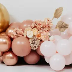 Złote i różowe balony z kwiatami i liśćmi wachlarzowymi.