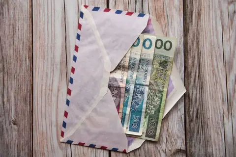 Koperta z pieniędzmi na komunię. Chrzestny zastanawia się, ile dać na komunię chrzestny.