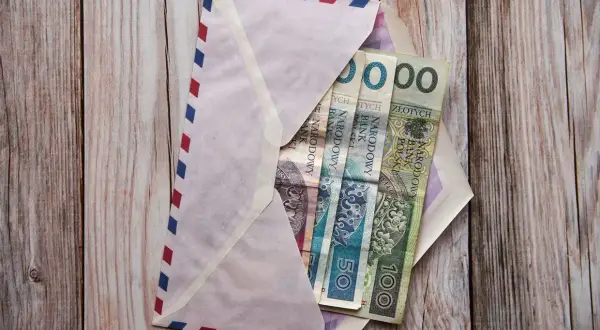Koperta z pieniędzmi na komunię. Chrzestny zastanawia się, ile dać na komunię chrzestny.