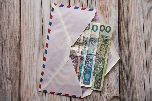 Koperta z pieniędzmi na komunię. Chrzestny zastanawia się, ile dać na komunię chrzestny.